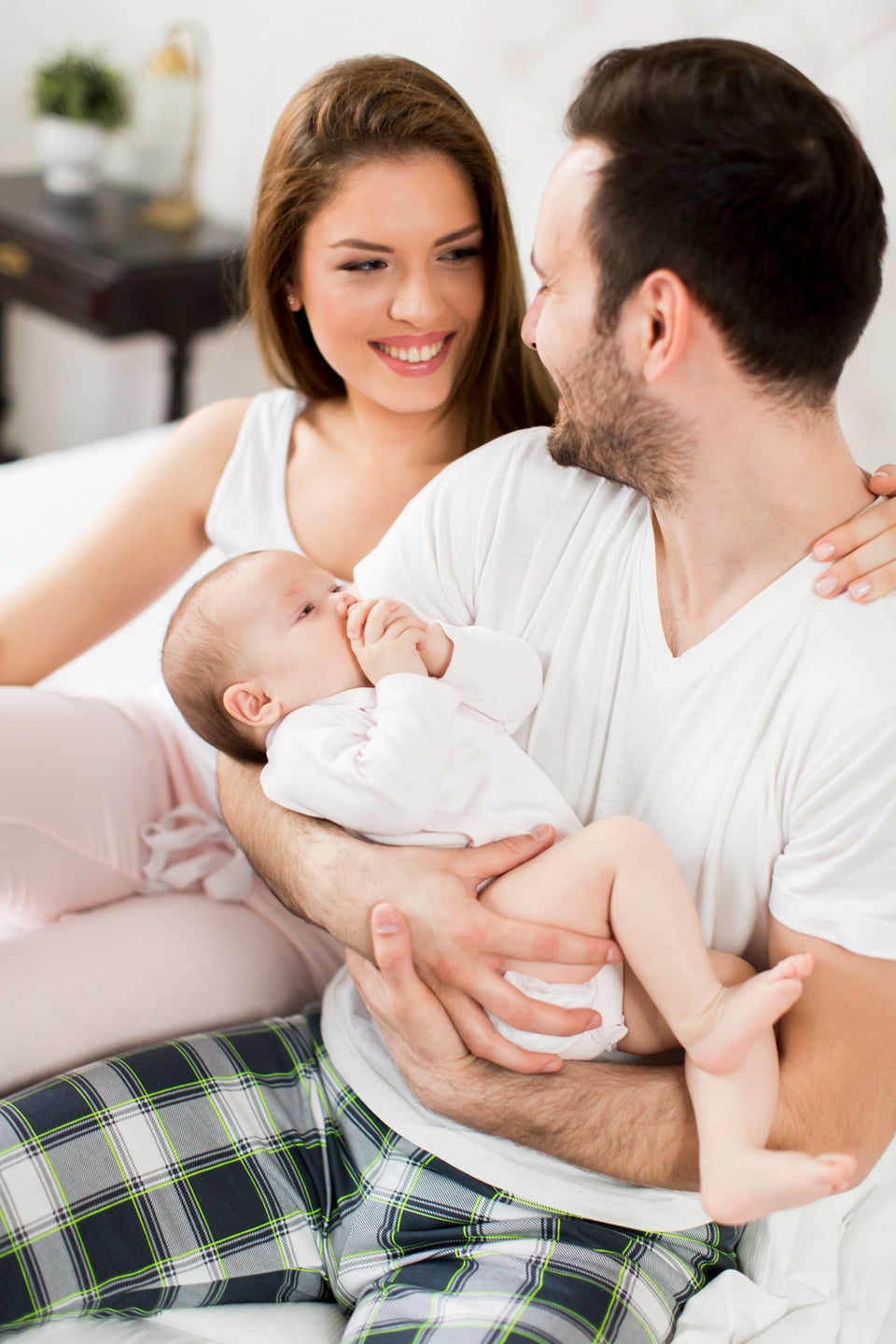 Happy couple with newborn baby representing successful surrogacy